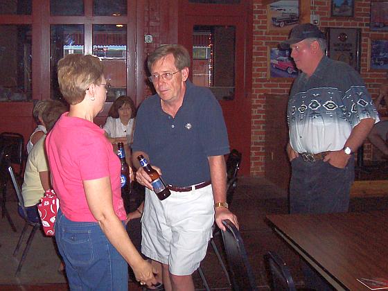 Susan Buettner Langenberg and Dennis Dannehl visit while Dennis Young sneaks up on them.