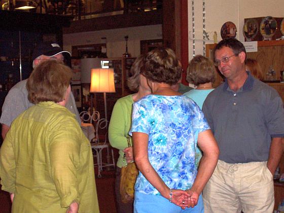 Roger Sand listens to wife Julie Winquist Sand, while others listen in.